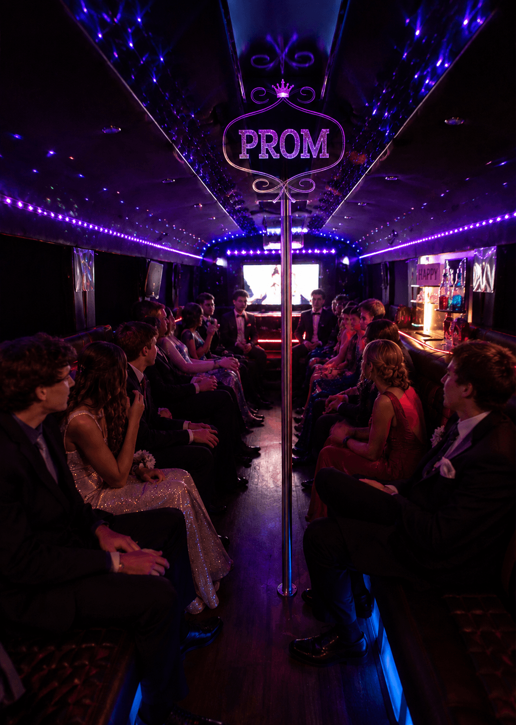 Students in formalwear enjoying the illuminated PROM party bus interior